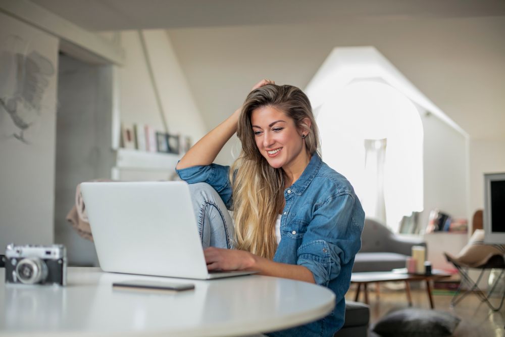 A woman using a laptop at a table.